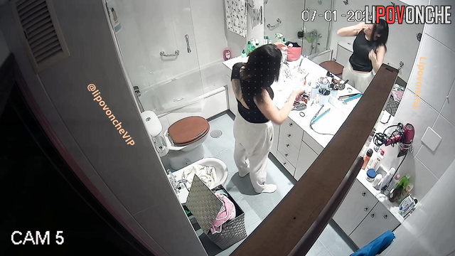 Brunette with big boobs changes clothes in the bathroom