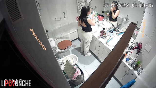 Brunette with big boobs changes clothes in the bathroom