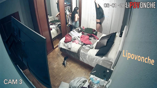 Two young brunettes preen themselves in front of a mirror and choose clothes