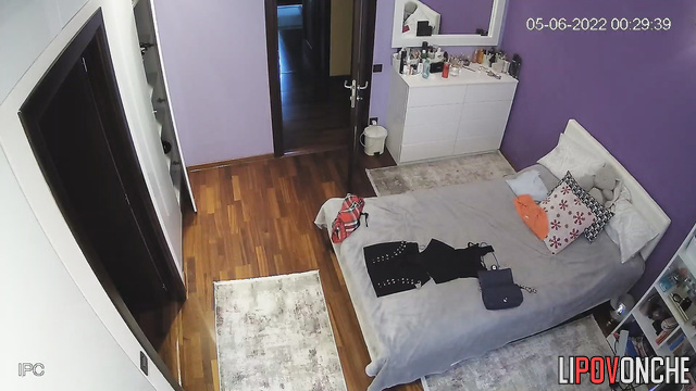 Skinny brunette with long hair changes clothes in front of the mirror