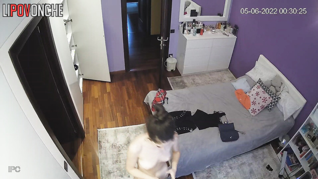 Skinny brunette with long hair changes clothes in front of the mirror