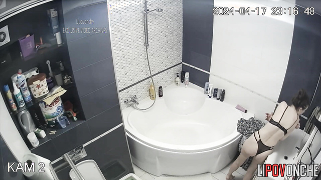 Skinny brunette bathing in front of a bathroom mirror