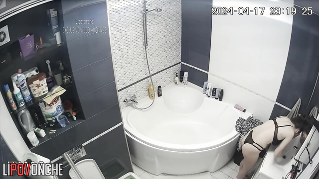 Skinny brunette bathing in front of a bathroom mirror
