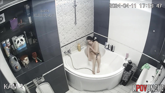 Long-haired brunette showering and is in no hurry