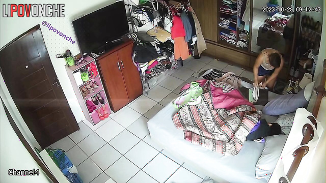 Tanned girl exposes her breasts while changing clothes in the bedroom