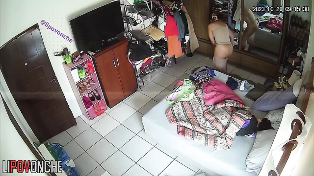 Tanned girl exposes her breasts while changing clothes in the bedroom