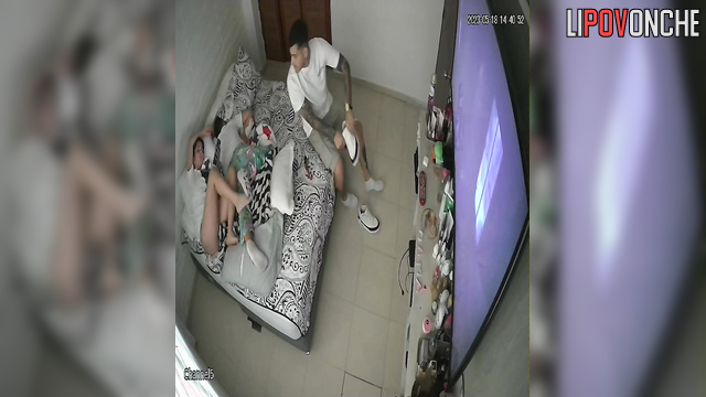 Close relatives relaxing on the bed and watching tv