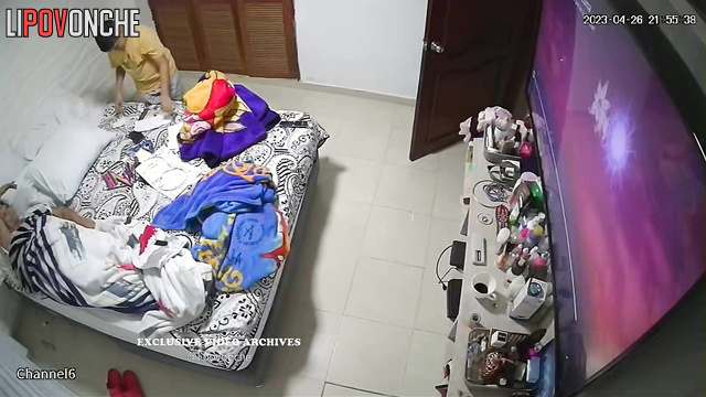 People chilling and watching tv in their small bedroom
