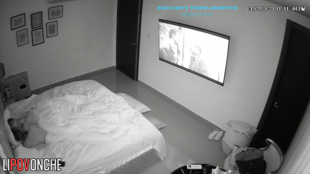 Naked couple watching interesting film under the blanket