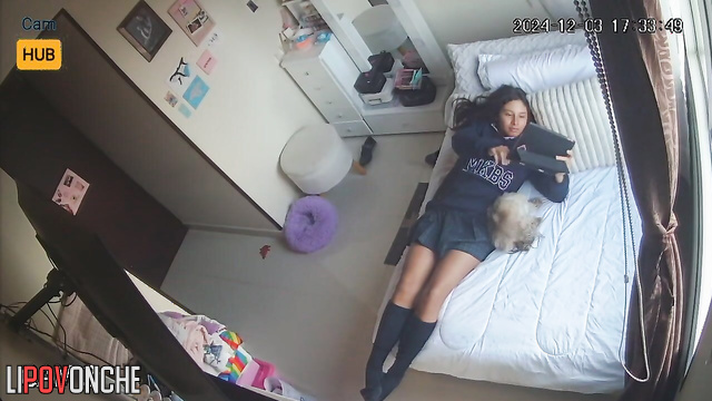 Cute schoolgirl relaxing with tablet on the bed
