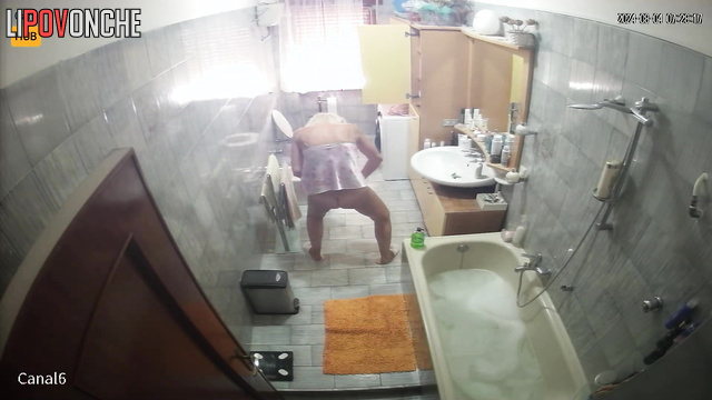 Blonde preparing for work (her husband periodically goes to the bathroom)