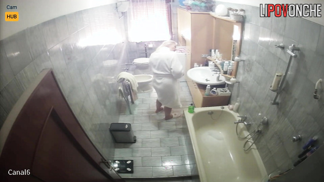 Blonde preparing for work (her husband periodically goes to the bathroom)