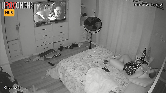 Chubby blonde watching tv and drinking wine at the same time