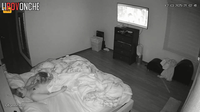 The husband relaxes while watching TV while his wife gives him a blowjob