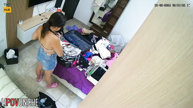 A pretty teenage girl tries on new outfits before going on a trip to a resort