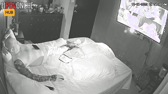 Tattooed guy in glasses watching boring v before sleep