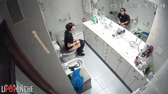 Pretty brunette sitting on the toilet and peeing