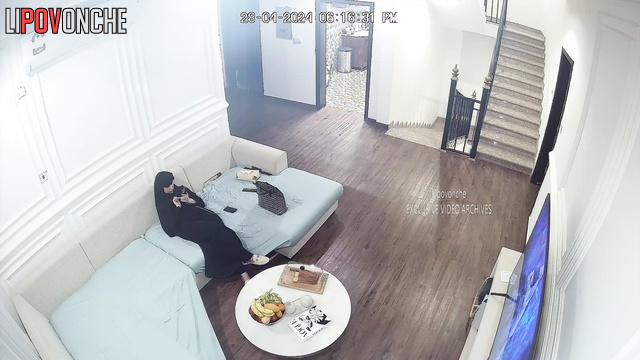 Lady in burqa relaxing on the sofa in a huge living room