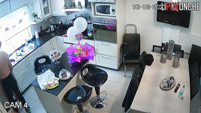 A young guy is making a pass at his redheaded girlfriend right in the kitchen
