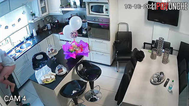 A young guy is making a pass at his redheaded girlfriend right in the kitchen