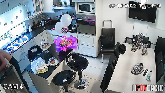 A young guy is making a pass at his redheaded girlfriend right in the kitchen