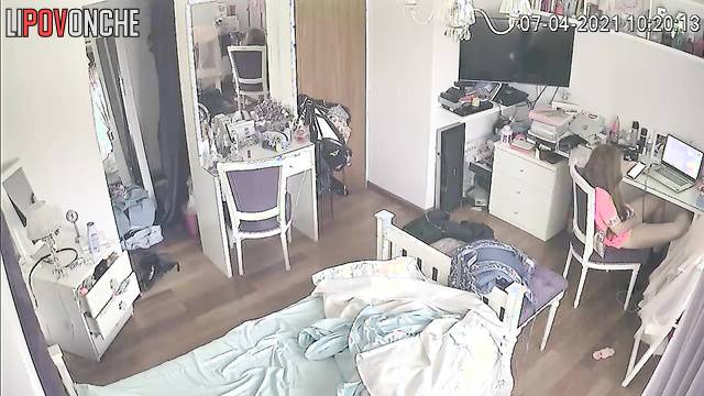 A teenage girl slips her playful fingers under her panties while watching porn