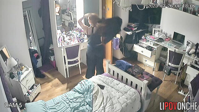 The redheaded girl undresses and gazes with interest at her firm tits in the mirror