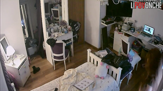 A red-haired teenage girl is taking a selfie in the mirror with her shorts pulled down