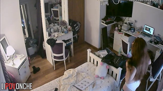 A red-haired teenage girl is taking a selfie in the mirror with her shorts pulled down