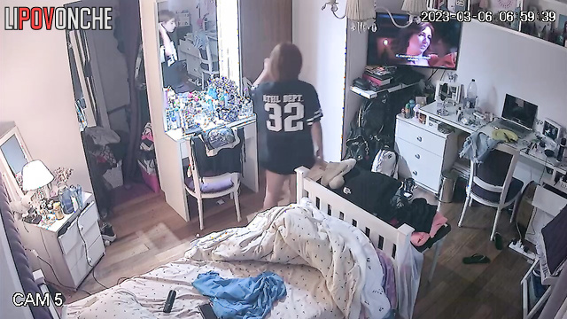 A pretty student admires the reflection of her bare breasts while putting on a bra