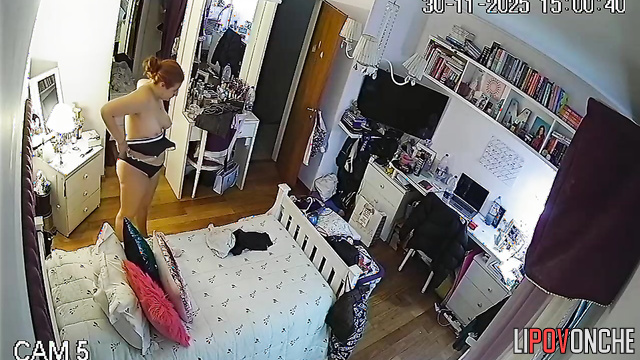 A seductive young woman admires her reflection after trying on a new bra