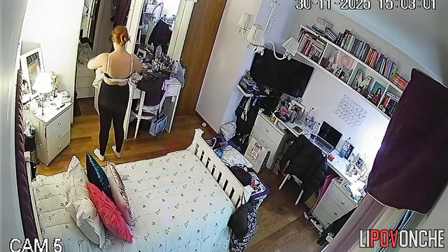 A seductive young woman admires her reflection after trying on a new bra
