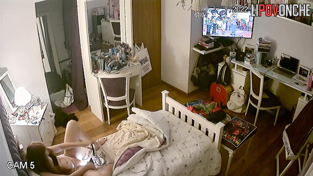 The redhead examines her wet pussy closely in the mirror, using her phone as a light