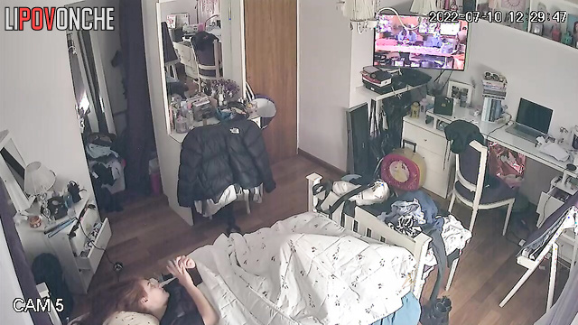 A girl with beautiful red hair is staring at the TV screen while having an orgasm