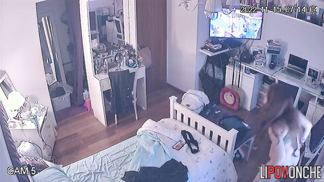 A long-haired beauty seductively takes off her panties while watching her reflection