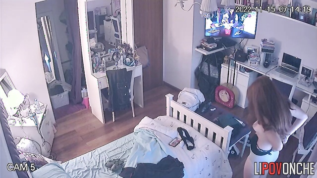 A long-haired beauty seductively takes off her panties while watching her reflection