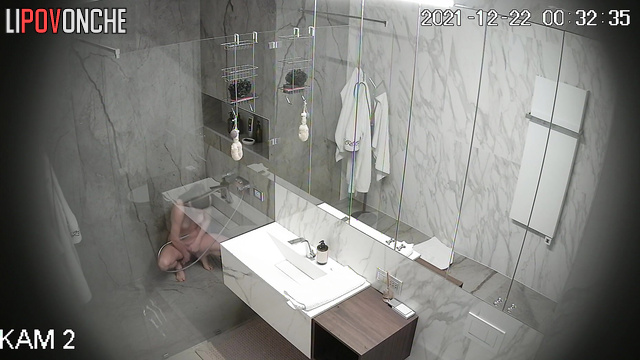 An athletic girl is vigorously lathering up her hairy pussy in the shower