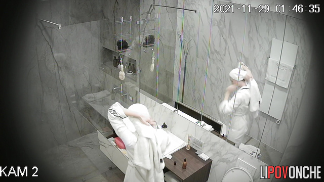 An sporty girl directs the warm stream of water from the shower onto her hairy pussy
