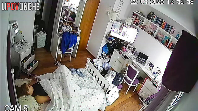 A bored redhead secretly masturbates under the covers while watching porn