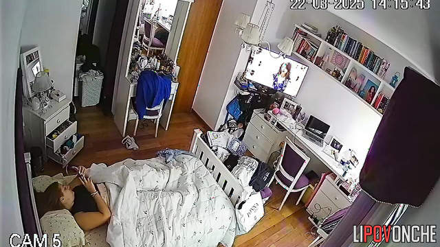 A bored redhead secretly masturbates under the covers while watching porn