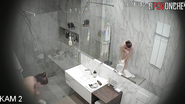 A naked girl with a sexy body and a hairy pussy is taking a shower