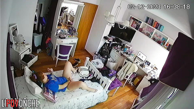 A red-haired cutie with a bare bottom pees into a cup right in her bedroom