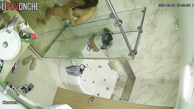 The transparent shower stall does nothing to hide the sexy brunette's naked body