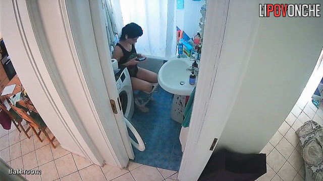 A sexy brunette arches seductively, washing her inviting butt
