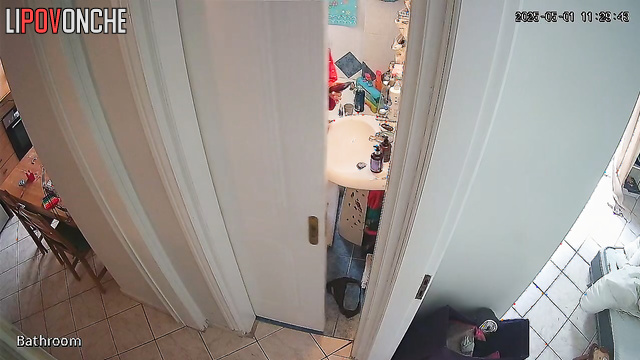 A girl with her bare bottom is standing in the bathroom holding a phone