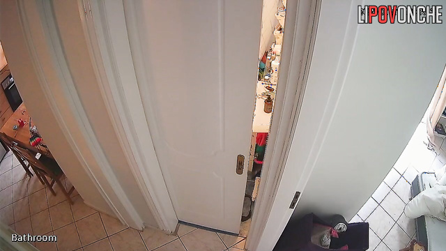 A girl with her bare bottom is standing in the bathroom holding a phone