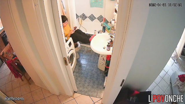 A young cutie has her legs up on the sink, sitting on the toilet with her bare ass