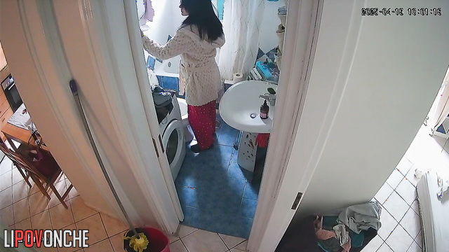 A housewife, sitting right on the toilet, spends a long time washing her butt