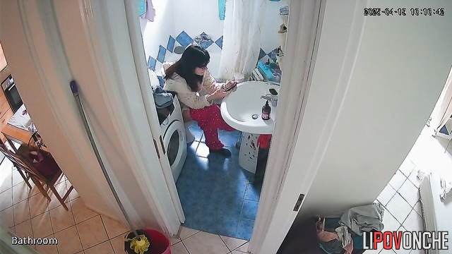 A housewife, sitting right on the toilet, spends a long time washing her butt