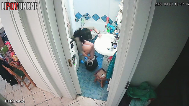 A cute brunette bares her sexy butt and shaved pussy while talking on the phone